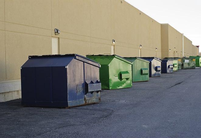 a fleet of red and blue construction dumpsters available for use in Dartmouth